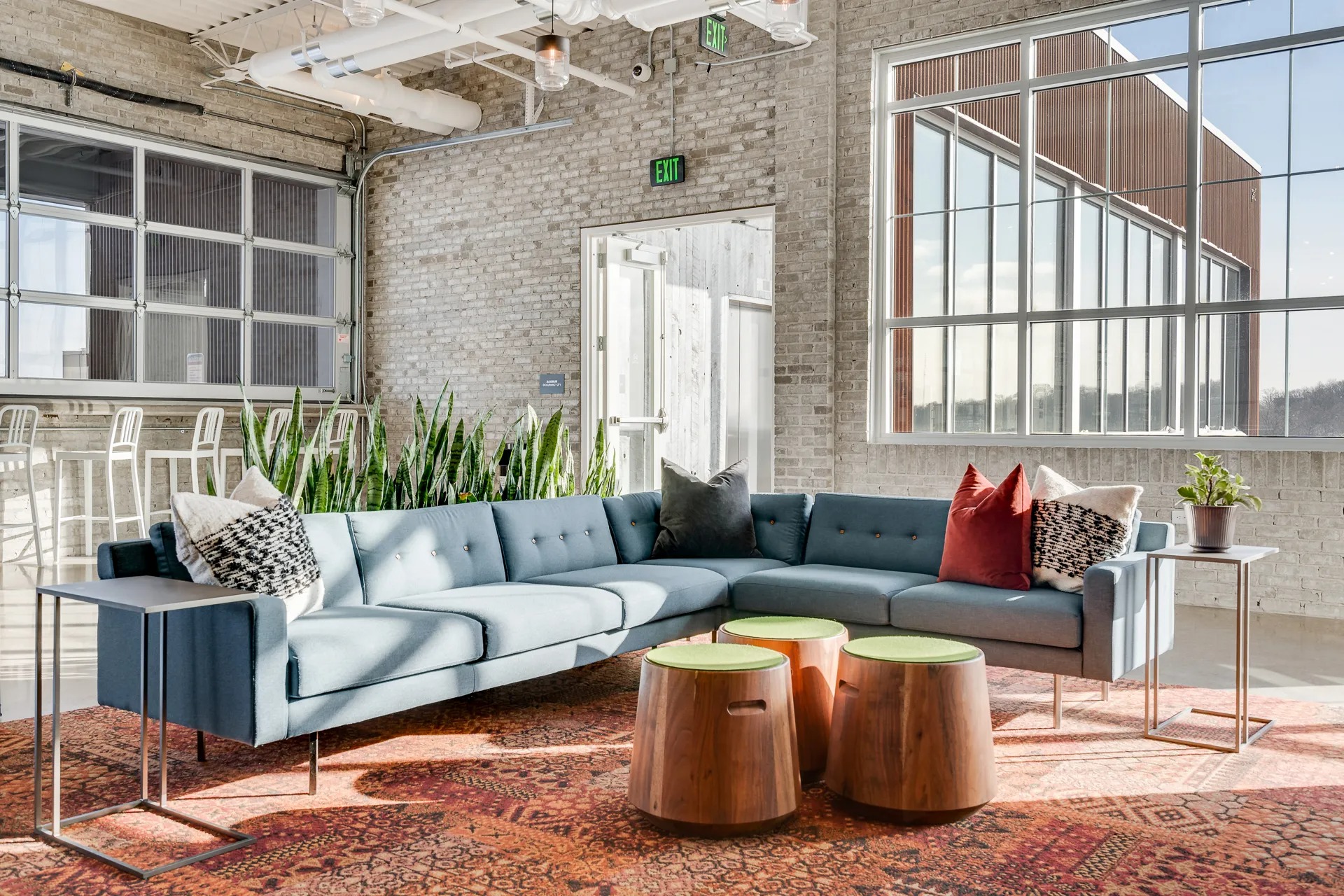 Large couch with pillows inside community rooftop amenity area at Max Apartments